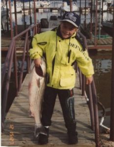 kid holding fish on dock